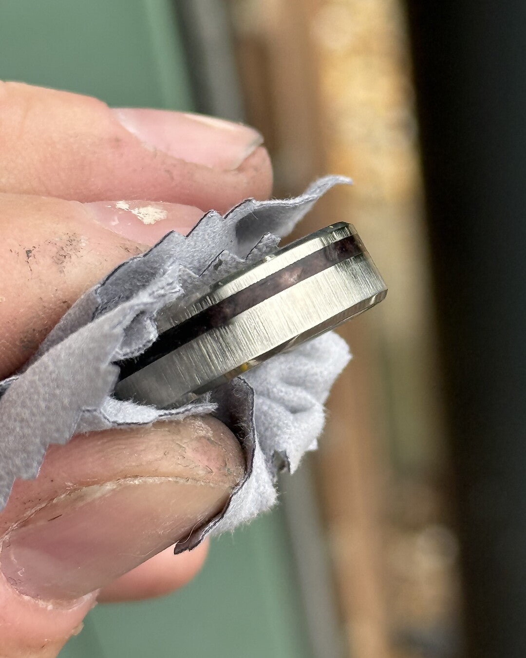 A handmade ring with a real meteorite inlay being finished at Featherlings