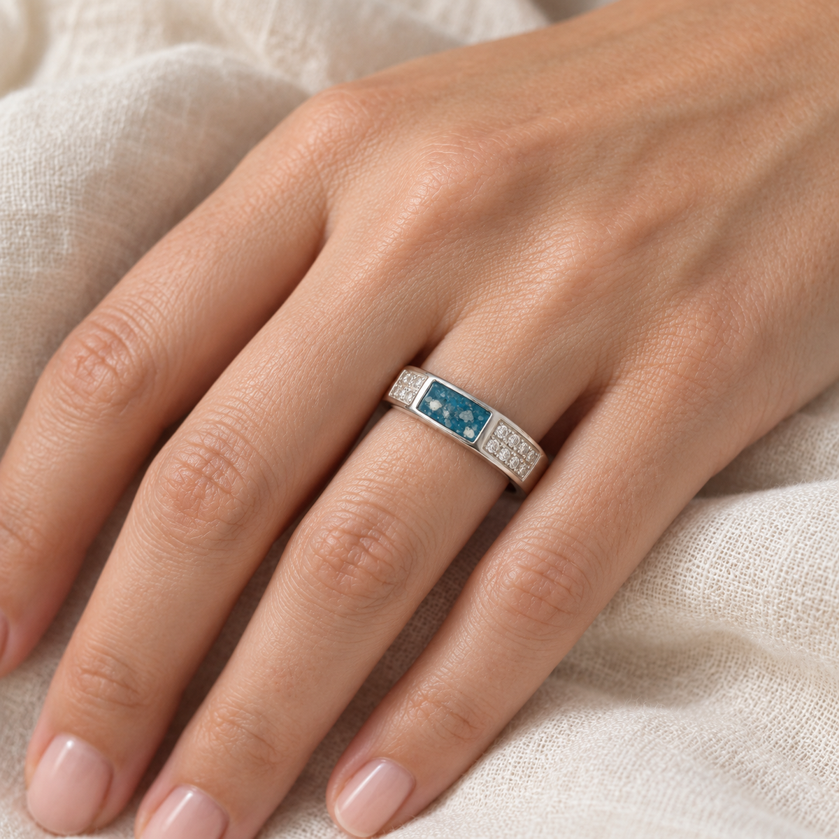 Illustrative worn view of Crystal Channel Ashes Ring in Sky Blue, visible ashes