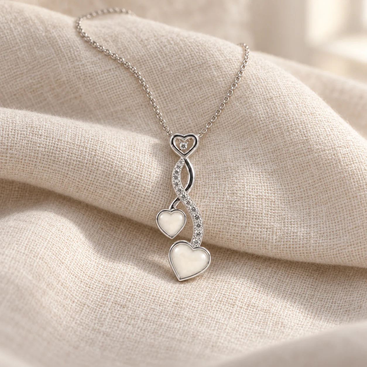 Entwined Hearts Breast Milk Necklace on pale linen — illustrative preview