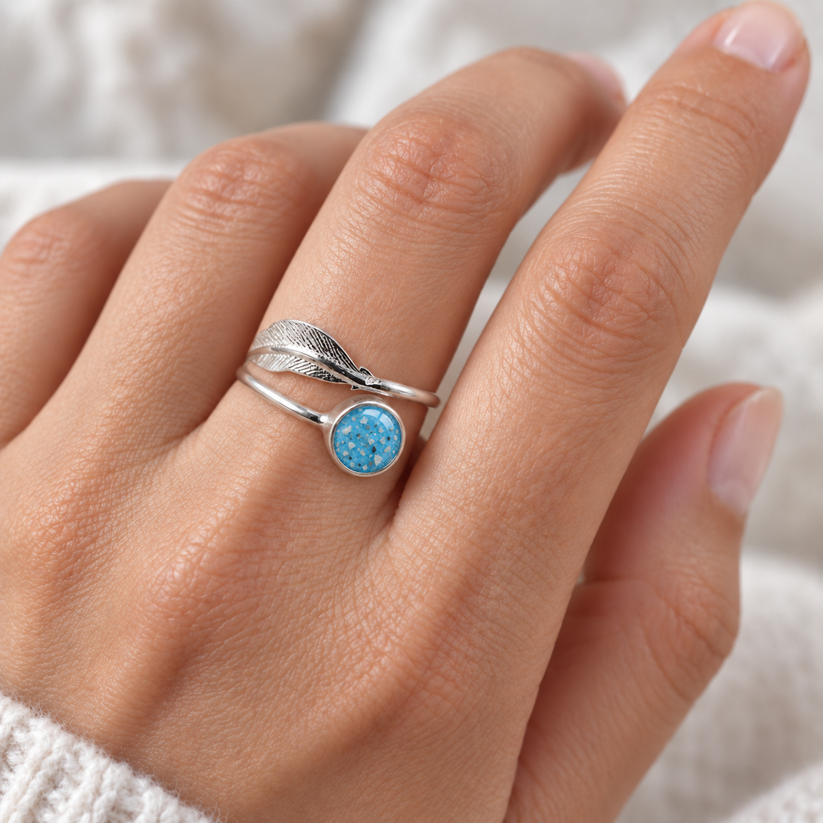 Adjustable Feather Ashes Ring worn on a hand