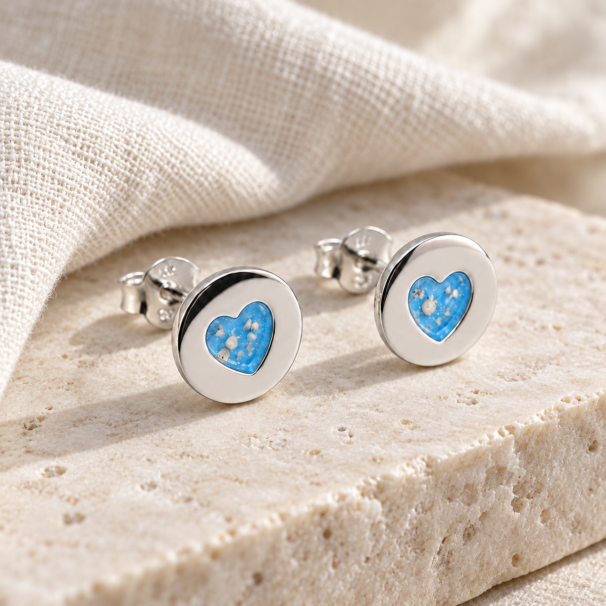 Illustrative lifestyle view of Tiny Heart Disc Ashes Earrings — Sky Blue, visible ashes