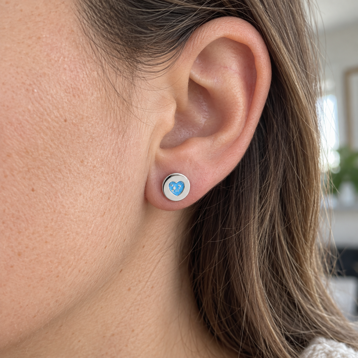 Illustrative worn view of Tiny Heart Disc Ashes Earrings — Sky Blue, visible ashes