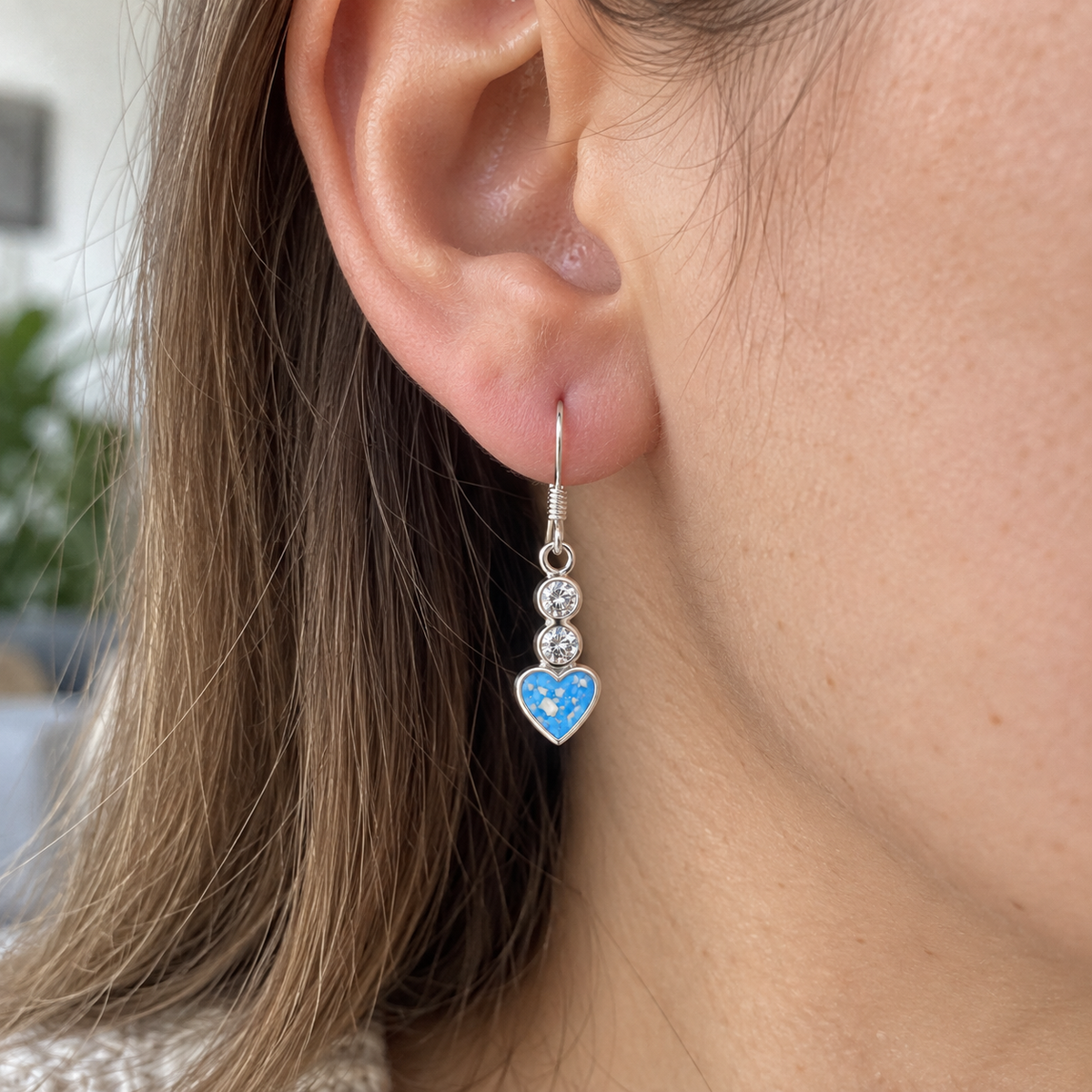 Illustrative worn view of Twin Crystal Heart Drop Ashes Earrings — Sky Blue, visible ashes