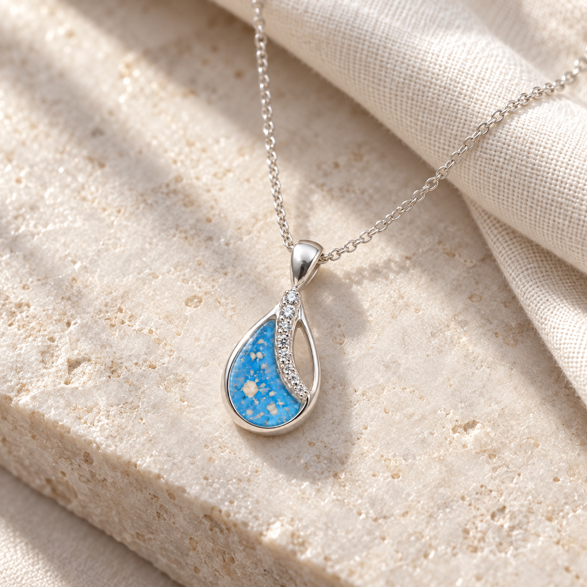 Illustrative lifestyle view of Crystal Sweep Teardrop Ashes Necklace — Sky Blue, visible ashes