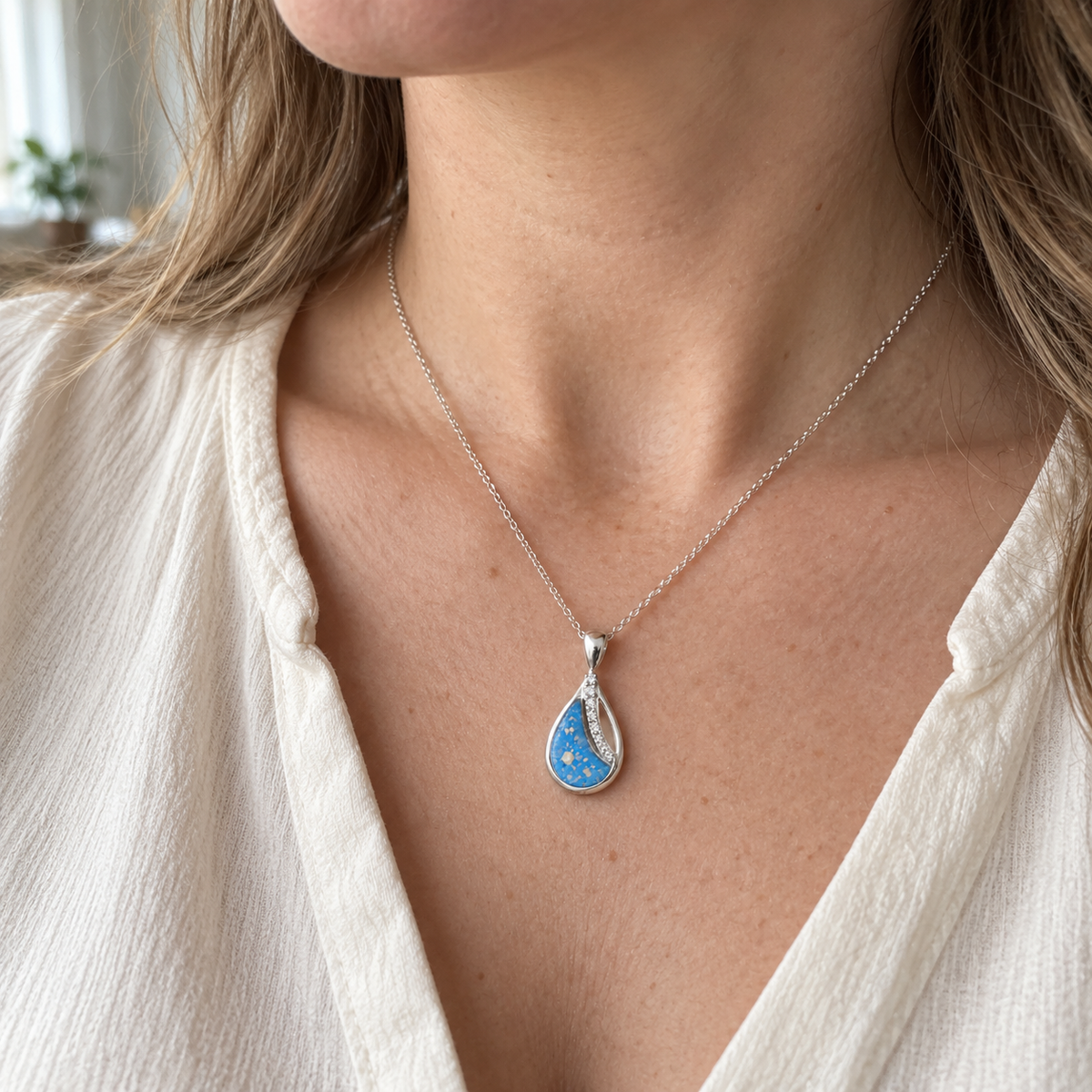 Illustrative worn view of Crystal Sweep Teardrop Ashes Necklace — Sky Blue, visible ashes