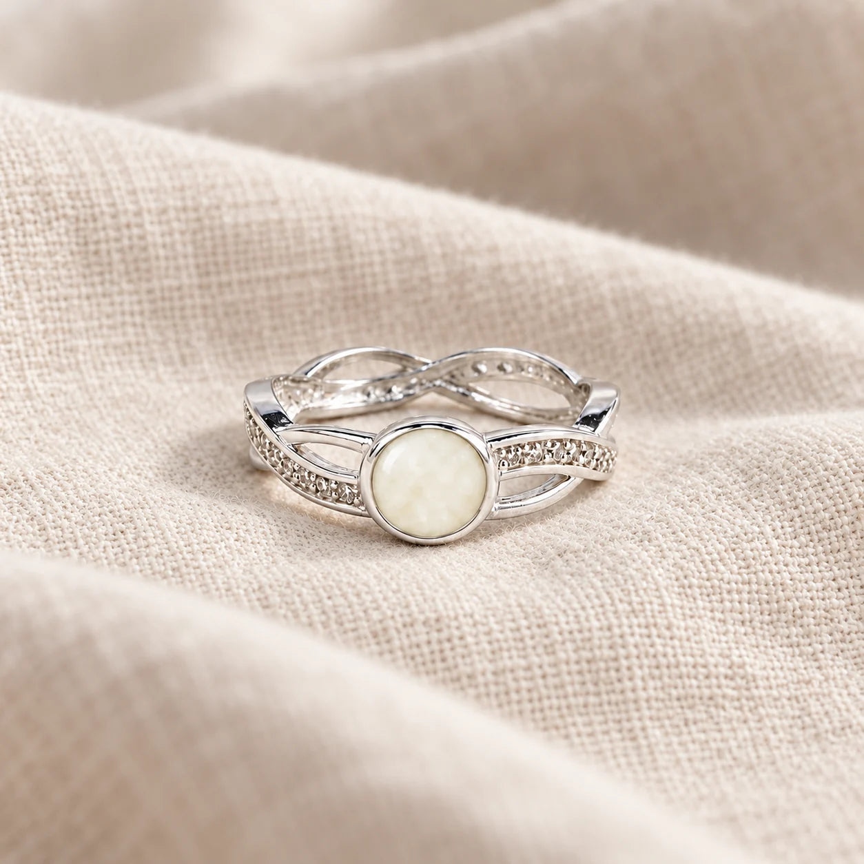 Entwined Breast Milk Ring on pale linen — illustrative milk jewellery preview