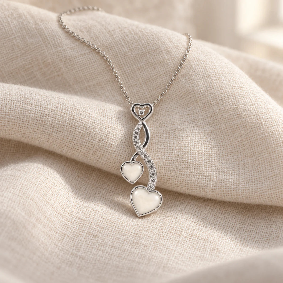 Entwined Hearts Breast Milk Necklace on pale linen — illustrative preview