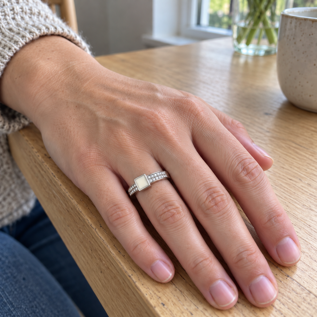 Illustrative worn view of square crystal breast milk ring